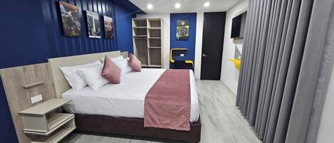 A modern bedroom with a bed, bedside tables, a wardrobe, and a TV.