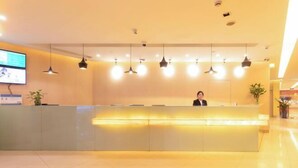 Un comptoir d’accueil au design moderne, plusieurs luminaires suspendus et un téléviseur à écran plat fixé au mur.