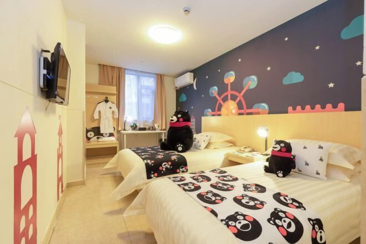 A hotel room with two beds, a TV, a wardrobe, a desk, and a nightstand.
