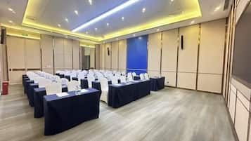A conference room with rows of tables and chairs, equipped with nameplates and water bottles.