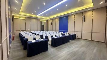 A conference room with rows of tables and chairs, equipped with nameplates and water bottles.