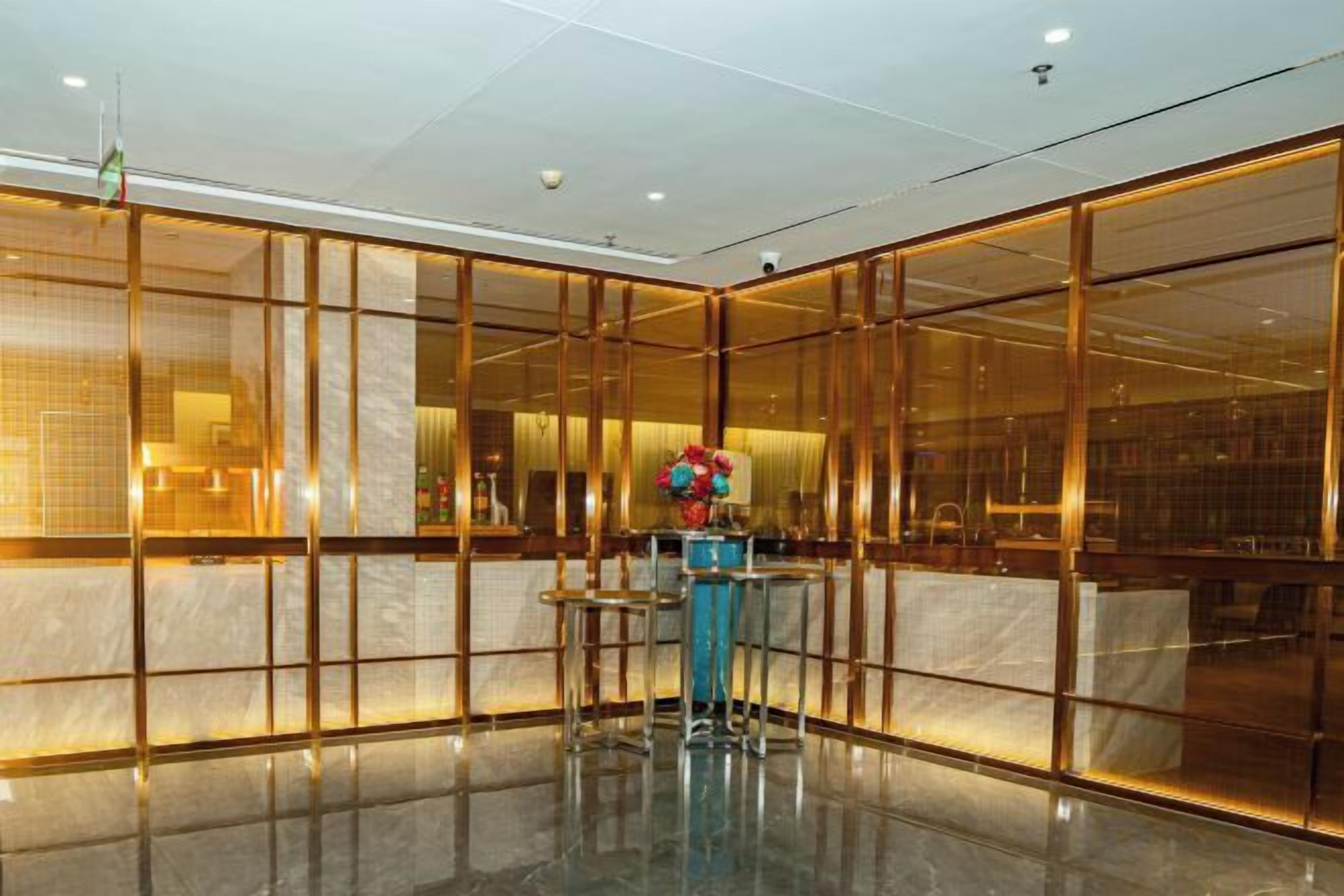 A lobby with a reception desk, a seating area, and a glass partition.