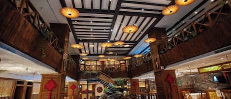 A spacious interior with high ceilings, wooden beams, and traditional lanterns.