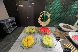 Mesa de buffet con diversos alimentos y un letrero que indica opción vegetariana.