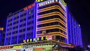 Un hôtel à plusieurs étages, doté d’une enseigne lumineuse et d’une entrée imposante.