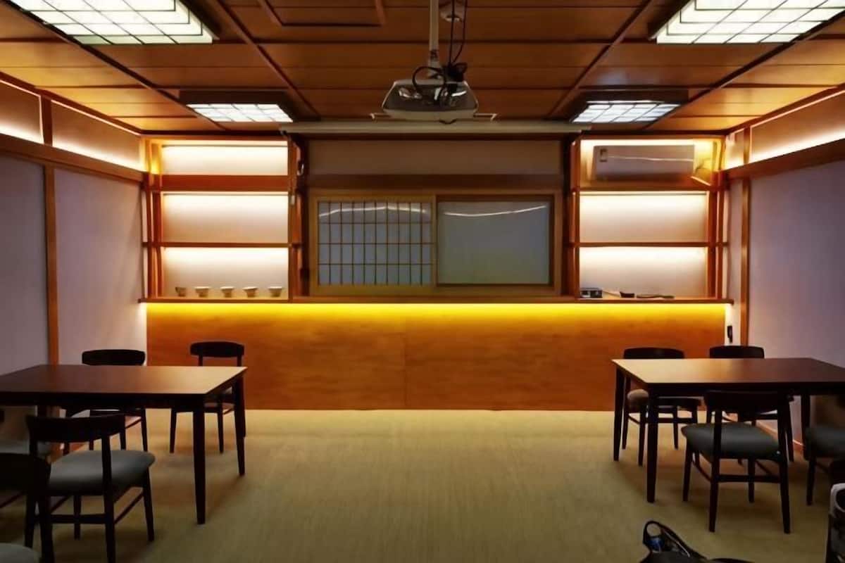 Une pièce avec des boiseries, un comptoir d’accueil, ainsi que plusieurs tables et chaises.
