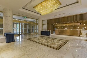 A hotel lobby with marble flooring, a reception desk, and a large chandelier. - Eastern Garden Hotel (Beijing)