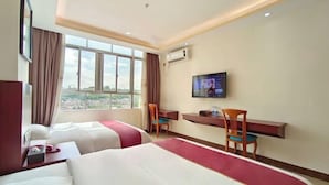 Una camera d'albergo con due letti, una scrivania, una televisione e una finestra con vista sulla città.