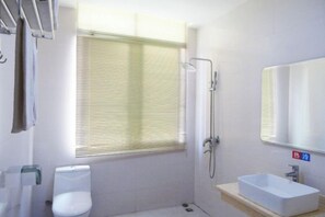 A bathroom with a shower, toilet, and sink. - Mingyue Business Hotel (Xinyi)