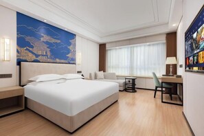 Une chambre d’hôtel moderne dotée d’un grand lit, d’un bureau et d’un coin salon.