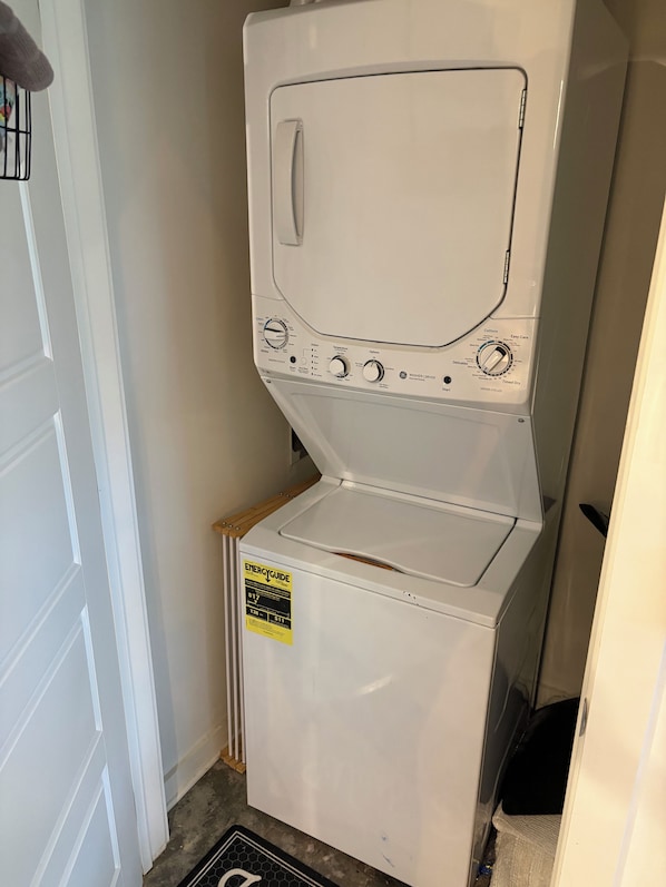 A white washing machine with a control panel, a sticker indicating energy efficiency, and a door.