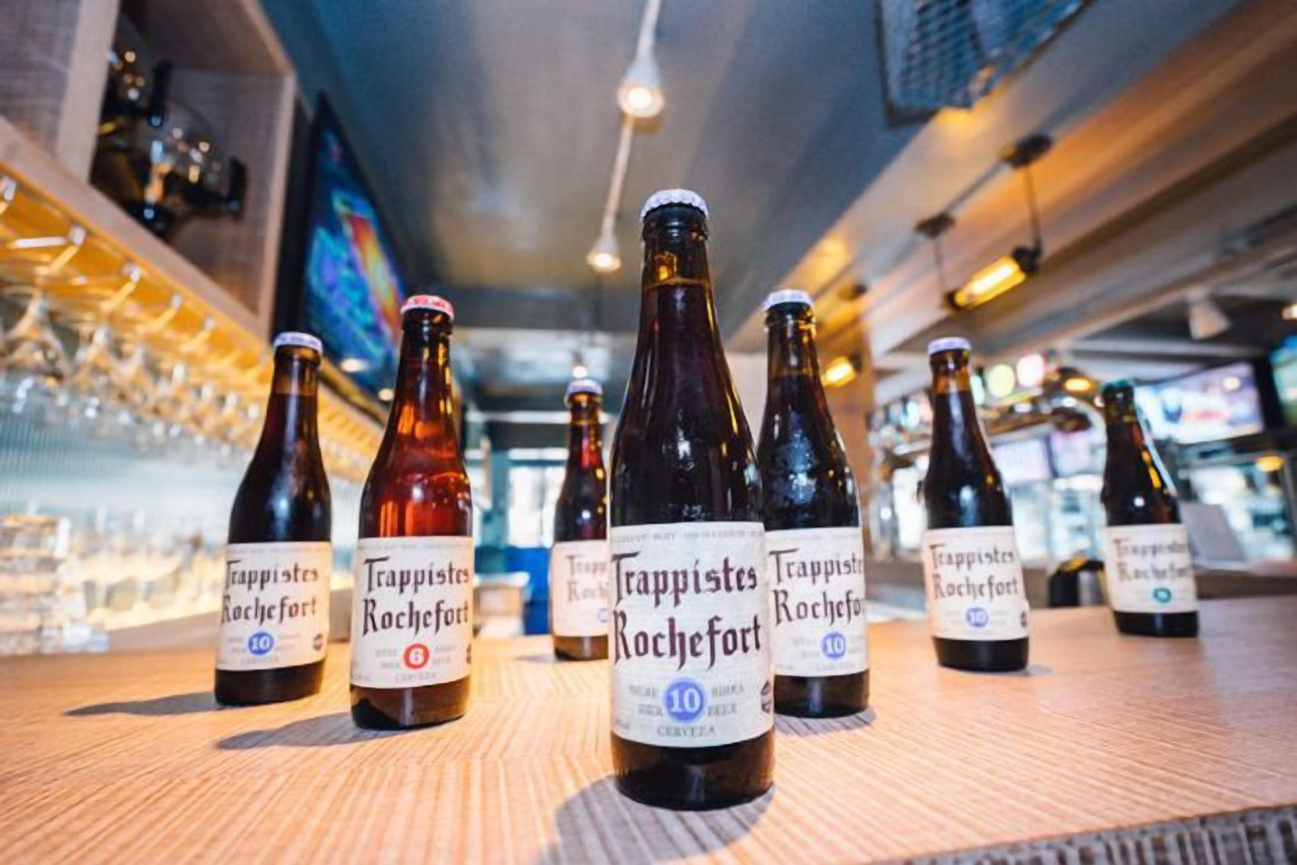 Bottles of Trappist Rochefort beer on a bar counter.