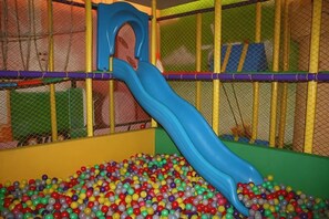 A play area with a slide and ball pit.