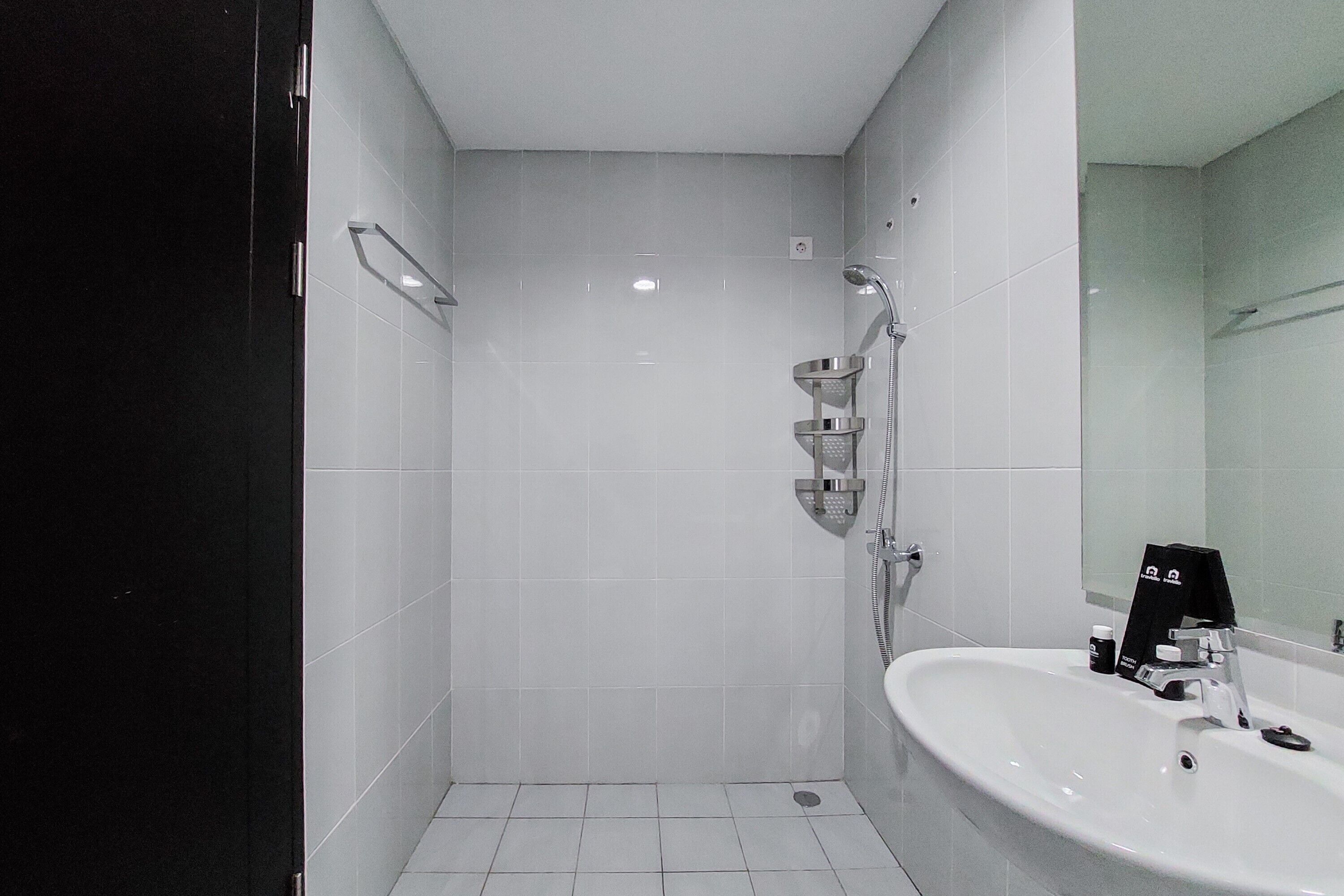 A modern bathroom with a shower, sink, and mirror.