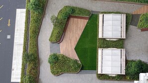 An aerial view of a parking lot with neatly arranged green hedges and a central paved area. - Comfort Designed 2Br At Tokyo Riverside Pik 2 Apartment (Teluknaga)