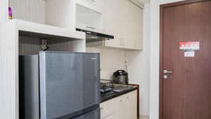 A compact kitchen with a stainless steel refrigerator, a microwave, and a kettle on the countertop. - Best Choice 2Br Parkland Avenue Apartment (South Tangerang)