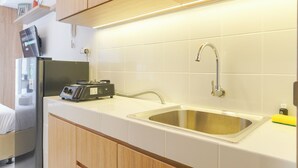 Eine moderne Küche mit Spüle aus Edelstahl, Holzschränken und eingebautem Toaster.