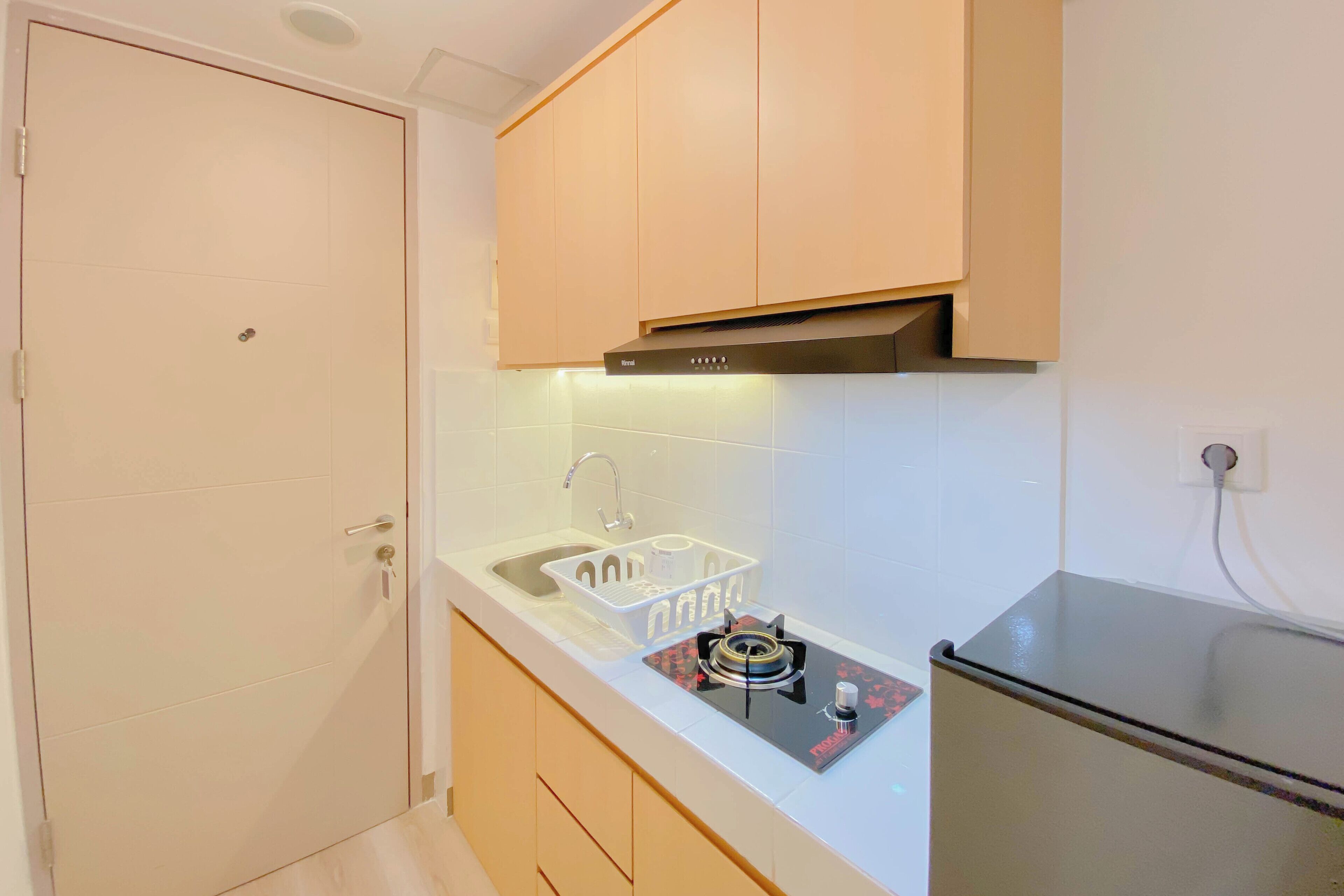 A compact kitchen with a built-in gas stove, a sink, and wooden cabinets.