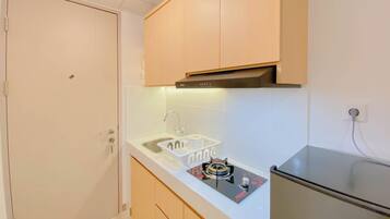 A compact kitchen with a built-in gas stove, a sink, and wooden cabinets.