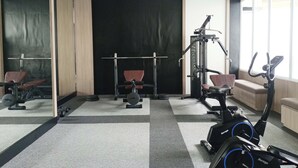 A gym with exercise equipment, a mirror, and a window.