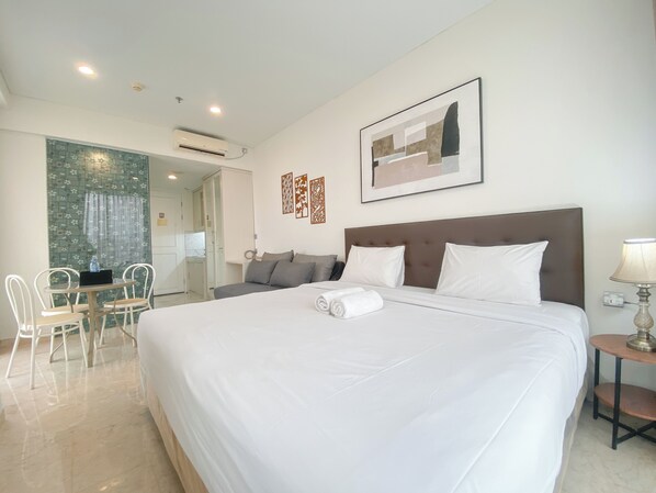 Relax in a spacious room with a large bed, tufted headboard, and comfortable seating area.