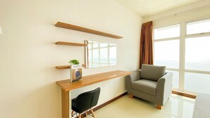 A modern living room with a grey sofa, a wooden console table, and a black chair. - Best Homey And Spacious 3Br At Green Bay Condominium Apartment (Jakarta)
