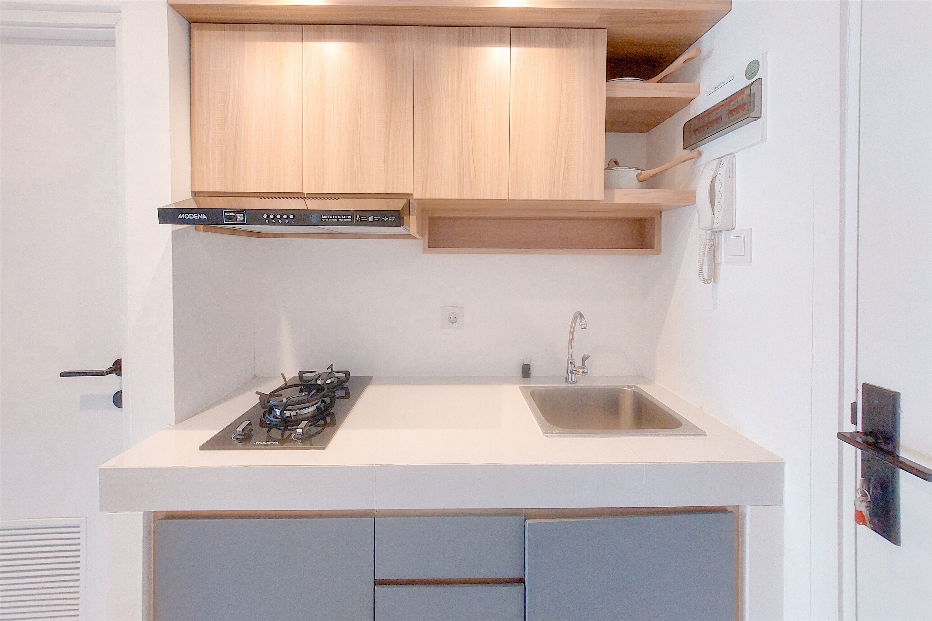 Una cocina moderna con armarios de madera, estufa a gas, pileta y horno empotrado.