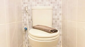 A standard toilet with a towel provided for guest comfort.