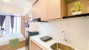 Enjoy a compact kitchenette with a stainless steel sink, modern faucet, and ample storage.