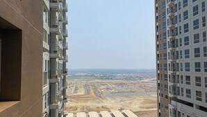 Ein Hochhaus mit mehreren Balkonen und im Hintergrund der Blick auf eine Baustelle.