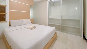 A bedroom with a large bed, a wardrobe, and a mirror. - The Cozy Cranny 2Br At Galeri Ciumbuleuit 1 Apartment (Bandung)