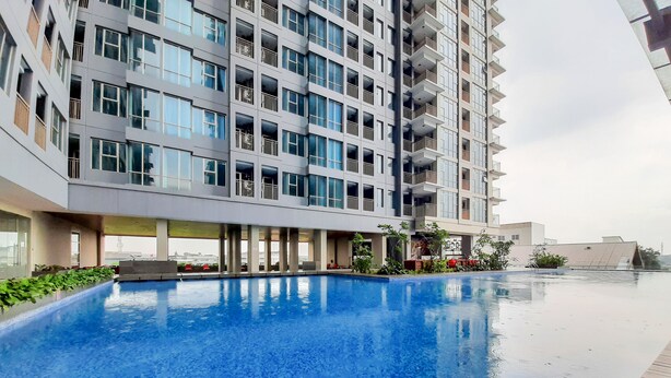 A modern building with a swimming pool and outdoor seating area. - Minimalist And Cozy Studio Tamansari Iswara Apartment (Bekasi)