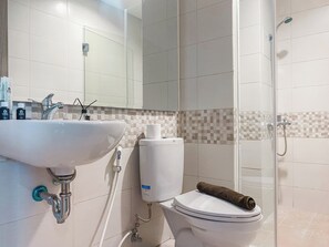 A bathroom with a sink, toilet, and shower. - Comfort And Well Furnished 2Br Tamansari Iswara Apartment (Bekasi)