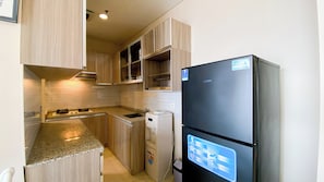 Apartamento | Cozinha privada | Geladeira, cooktop, panela elétrica de arroz, mesas de jantar