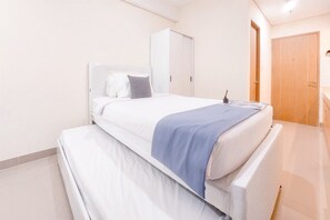 A bedroom with a bed, a wardrobe, and a door. - Good Place And Relaxing Studio Apartment At B Residence (Pagedangan)
