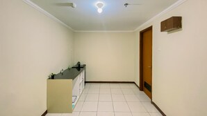 Un couloir avec un coin cuisine, un ventilateur de plafond et une porte.