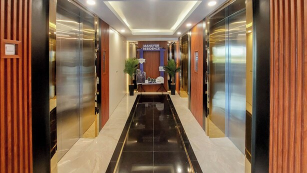 Un moderno vestíbulo de hotel con una recepción central, ascensores y un suelo pulido.