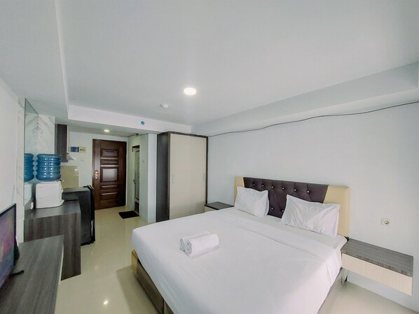 Relax in a stylish room with a comfortable bed, bedside table, and ample storage in the wardrobe.