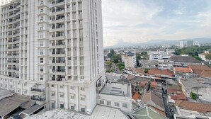 Un edificio de gran altura con varios balcones y vistas a un paisaje urbano.