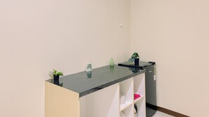 A small, modern kitchenette with a marble countertop, a sink, and a potted plant. - Spacious Studio (No Kitchen) At Grand Palace Kemayoran Apartment Near Jiexpo (Jakarta)