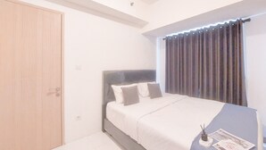 Un dormitorio con una cama, una puerta de madera y una ventana con cortinas.