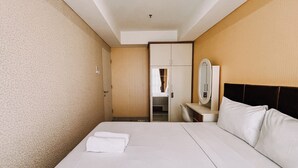 A hotel room with a bed, a bedside table, a mirror, and a wardrobe. - Good Deal And Restful 1Br Apartment Tamansari Skylounge Makassar (Makassar)