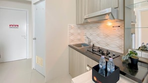 A modern kitchen with a gas stove, stainless steel sink, and a black water dispenser.