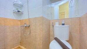 A bathroom with a shower, toilet, and a small shelf with toiletries.