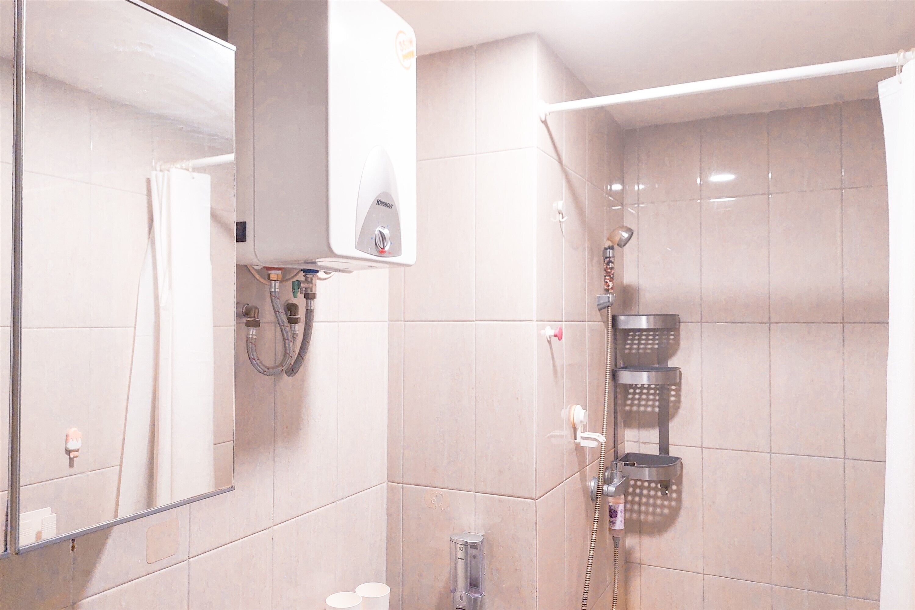 A modern bathroom with a built-in shower, a mirror, and a towel rack.