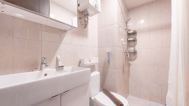 A bathroom with a sink, toilet, and shower.