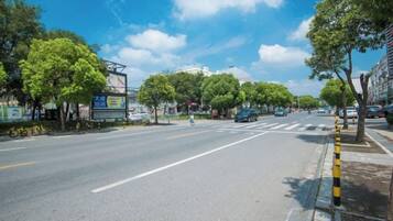 A wide street with trees and buildings on both sides.