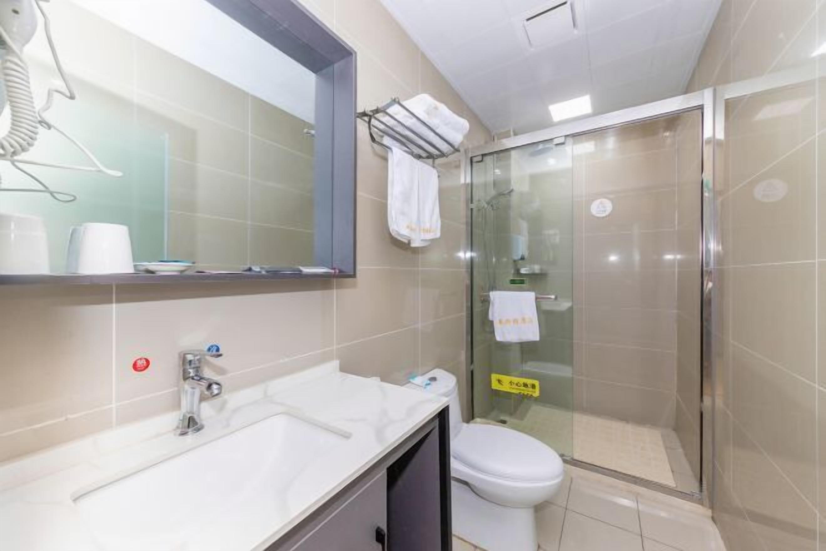 Un baño con lavamanos, espejo e inodoro.
