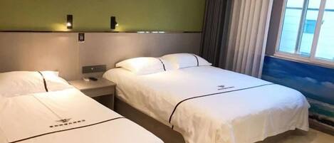 A hotel room with two beds, a nightstand, a wall-mounted lamp, and a window with curtains.
