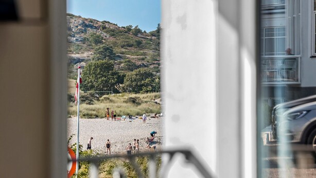 Une plage avec des gens, un drapeau et une colline en arrière-plan.
